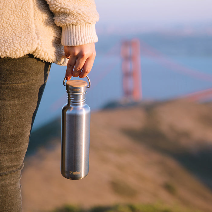 27oz-reflect-with-bamboo-cap-g3 K27SSLRF-BS-BAMBOO_reflect_bottle_bridge_lifestyle.jpg